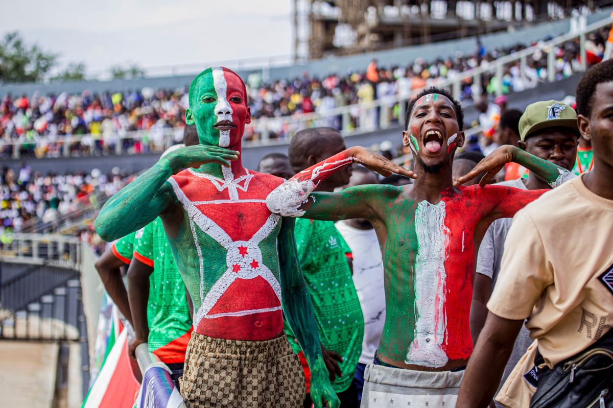 Football supporters with painted faces in a stadium